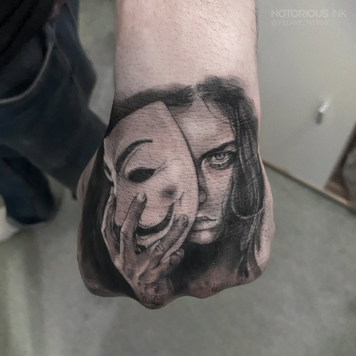 Anonymus mit Frauen Gesicht auf der Hand - Tattoo und Piercing